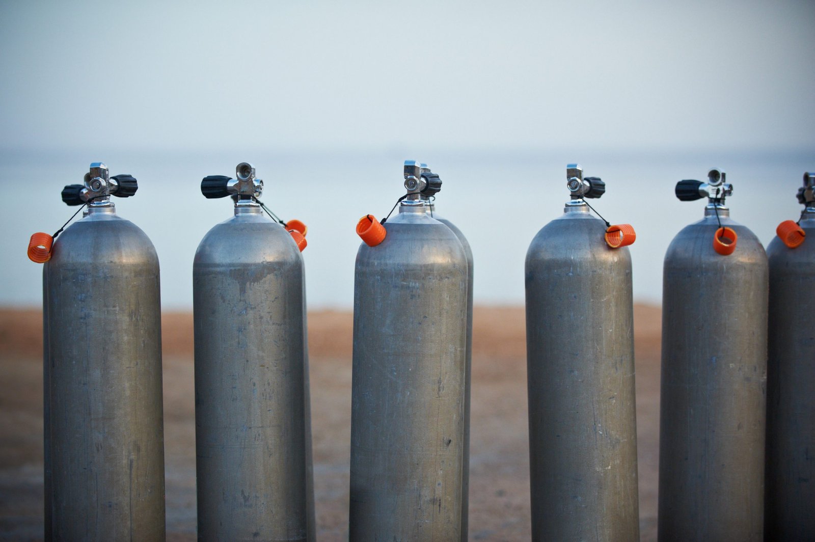 Collection of grey scuba diving air oxygen tanks waiting lined up.