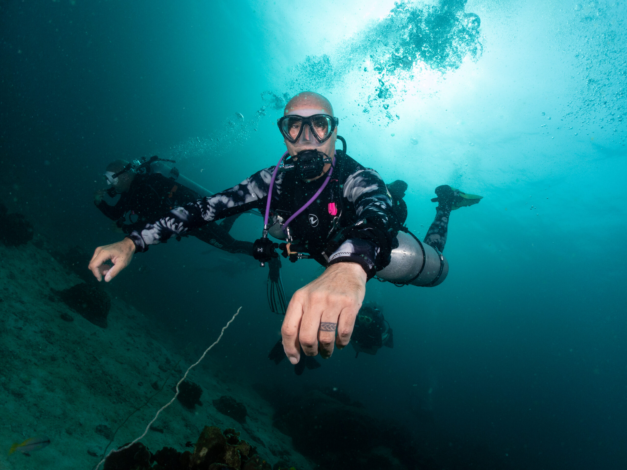 PADI Sidemount Instructor supervising a student underwater, ensuring safe gas management, proper body position, and comfort during sidemount practice in Bali.