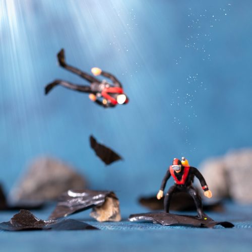 Miniature people , Scuba diver cleans up plastic rubbish pollution discarded in ocean, underwater pollution concept